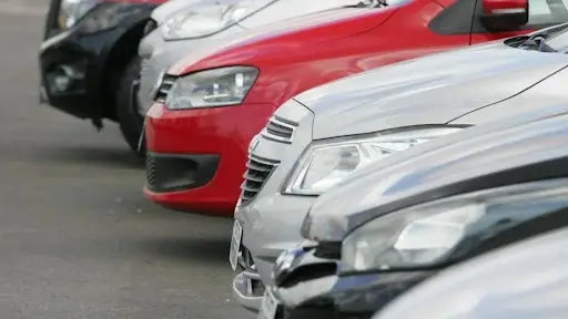 Vários carros estacionados em fila em um estacionamento.
