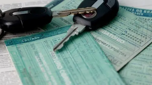 Chaves e documentos de carro sobre uma mesa