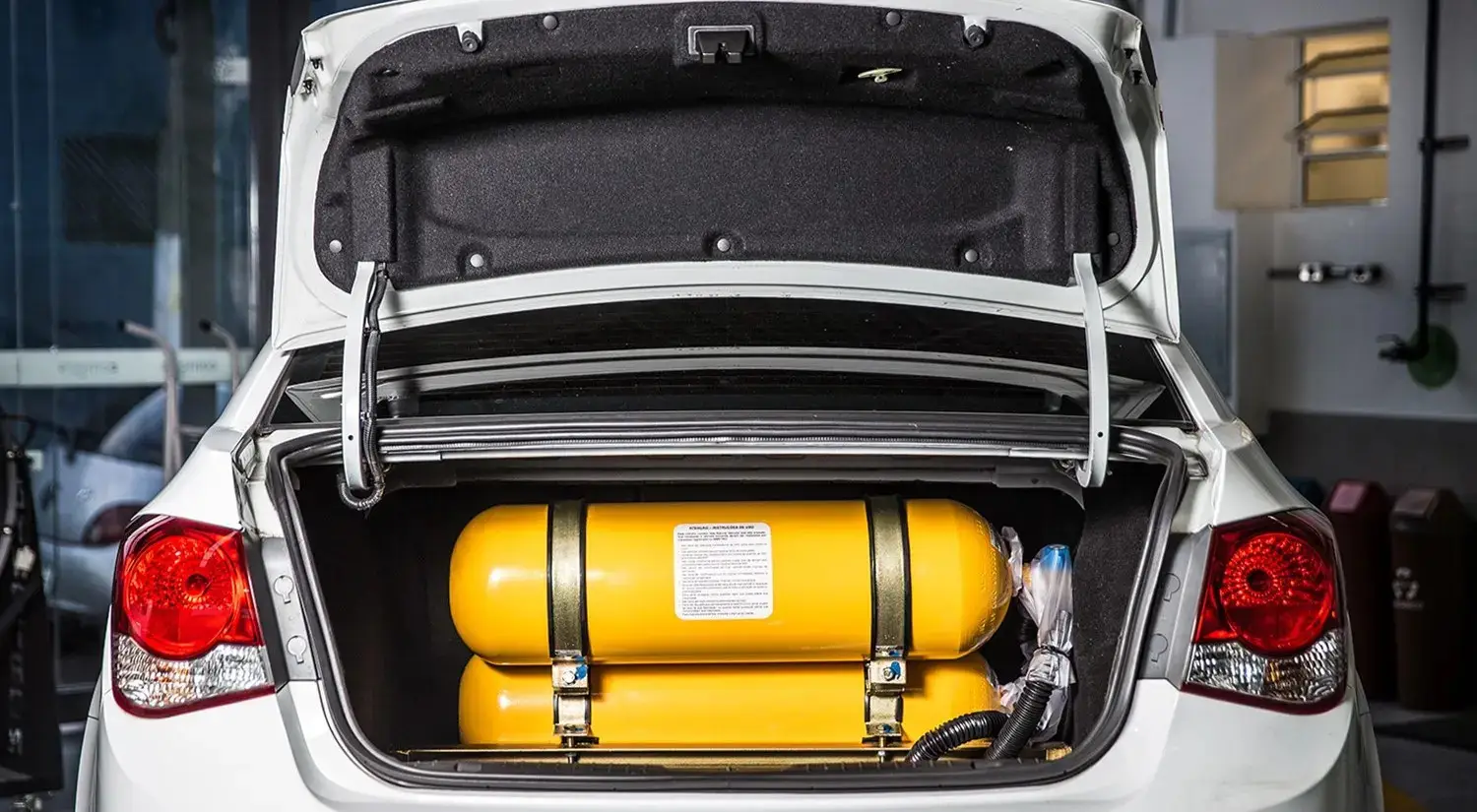 Tanque de gás amarelo no porta-malas de um carro