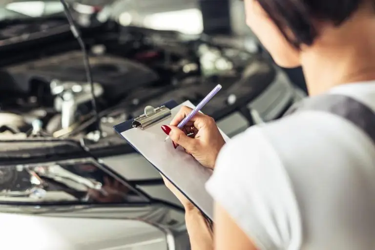 Mulher fazendo anotações em cheque técnico de carro