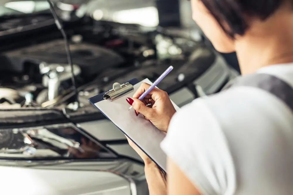 Mulher fazendo anotações em cheque técnico de carro