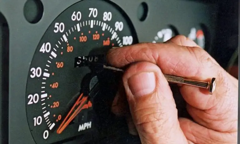 Painel de velocímetro sendo ajustado manualmente.